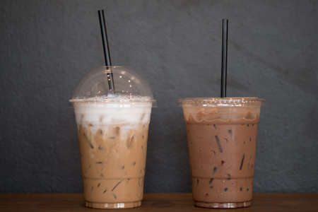 Two plastic cup of takeaway iced coffee with black background