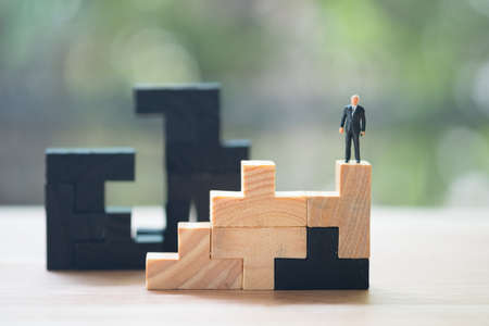 Miniature people: Businessman standing on puzzle pieces. Concept of leader different.の写真素材
