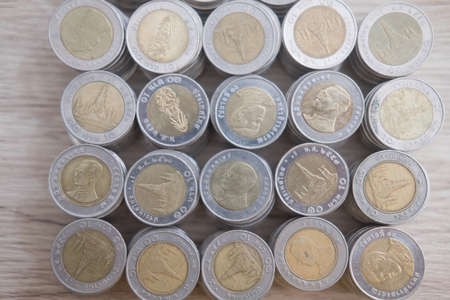 Many Thai baht coin stack on wood table