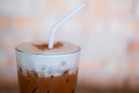 Glass of iced cocoa drink and milk froth cream foamの写真素材