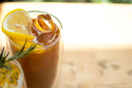 Glass of espresso shot mixed with orange juice and topped with fresh sliced orange