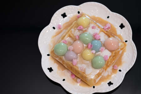 Bua Loi Thai dessert with colorful ball flour and coconut milk topped on waffle. Thai sweet creative
