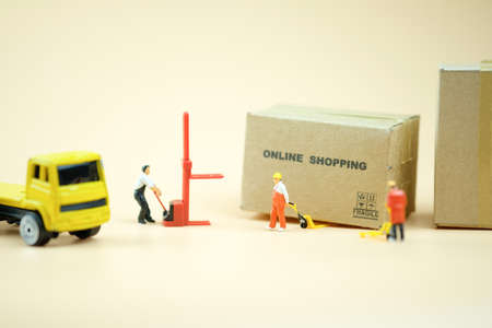 Miniature warehouse worker pulling a pallet truck with brown boxes prepare for transport order from online shopping. online shopping conceptの写真素材
