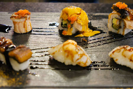 Japanese food in set different types of sushi is a healthy food serving black tray in japanese restaurantの写真素材