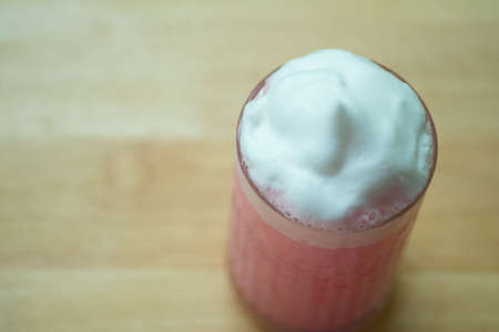 Pink milk iced with milk foam in glass. Trendy drink. Copy space for menu.の写真素材