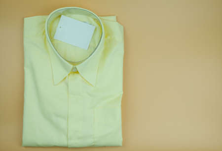 Men yellow shirts folded on a yellow background. Trendy fashion male
