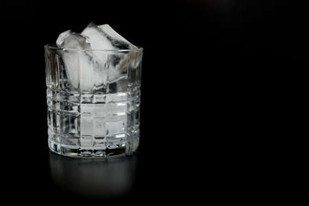 Ice cubes in empty glass on dark background.の写真素材