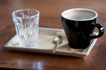 Empty hot coffee cup after drink on wooden trayの写真素材