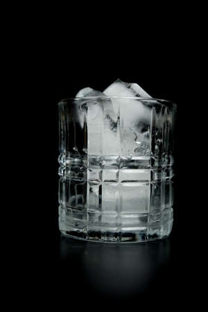 Ice cubes in empty glass on dark background.の写真素材