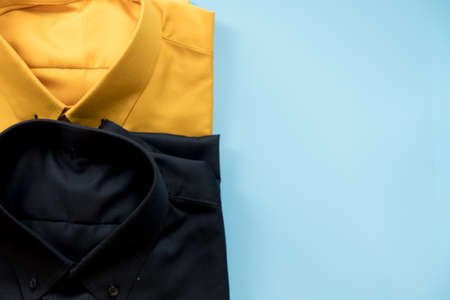 Top view of yellow and black shirt on blue backgroundの写真素材