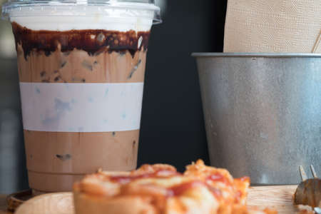 Iced coffee mocha on wood table with pizza toasted bread, breakfast menu