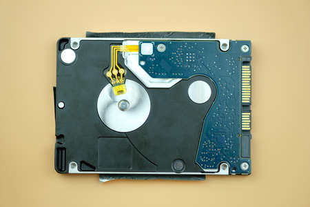 Top view of damaged external hard disk on orange backgroundの写真素材