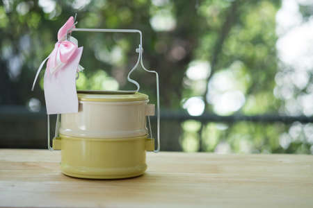 Metal tiffin Thai food carrier (pastel color) on wood table. Vintage food packagingの写真素材