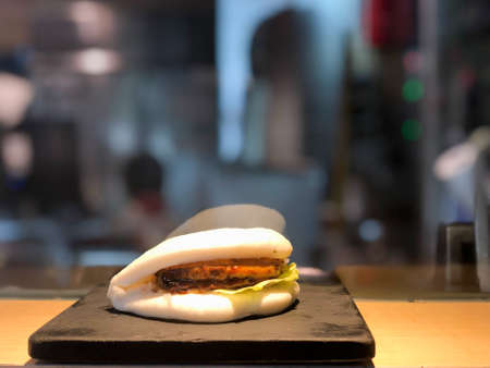 Steamed pork bao buns with veggies on black plateの写真素材