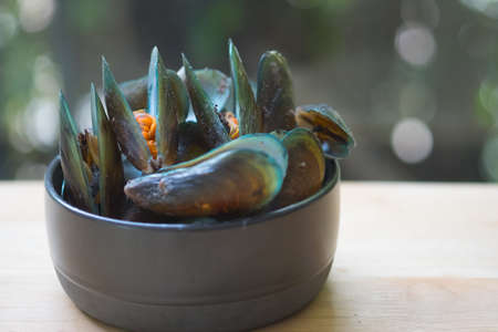 Thai food steamed mussels in bowl on wood table