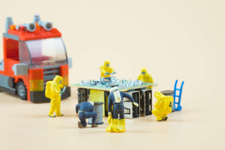 Tiny figures of chemical team in hazmat suits examining. Safety concept