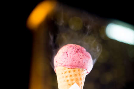 Hand holding of blueberry of ice cream cone waffle with light night backgroundの写真素材
