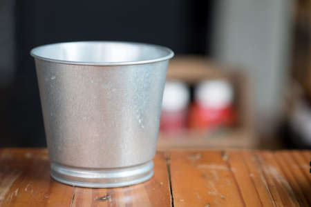 A metal buckets on wood tableの写真素材