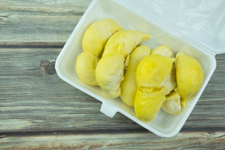 Fresh durian in foam box on wooden background. Close upの写真素材