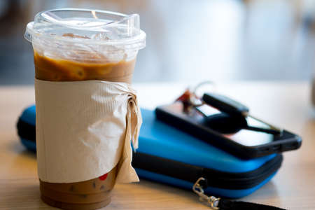 Iced coffee with tissues sleeve and lid, you can drink coffee pass lid replace straw. Concept of reduce the use of plastic straw. Reduce plastic waste in environment.の写真素材