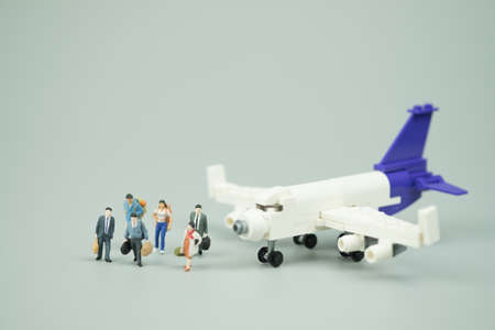 Miniature people businessman in suit and tie passenger with airplane. Using as business trip and travel or premium, luxury flight or first class concept.の写真素材