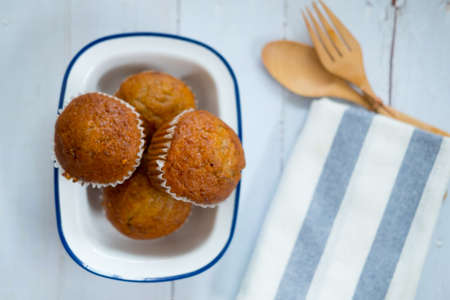 Banana cupcake in white bowl on wood table
