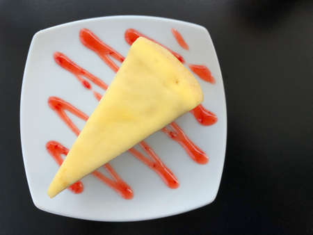 Piece of homemade cake put on strawberry sauce