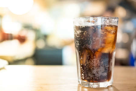 Cool soft drink with ice on wood table