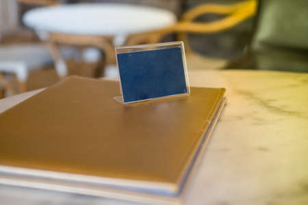 Display stand for acrylic tent card in coffee shop. mockup menu frame on table in bar restaurant. space for textの写真素材