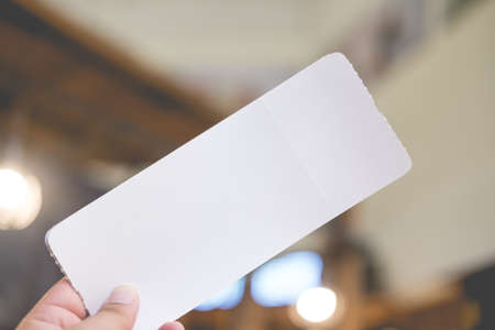 Empty paper air ticket in hand. Travel concept, copy space