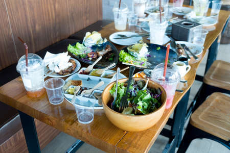 A table after eating healthy food together in the restaurant. Concept of group of people dining....
