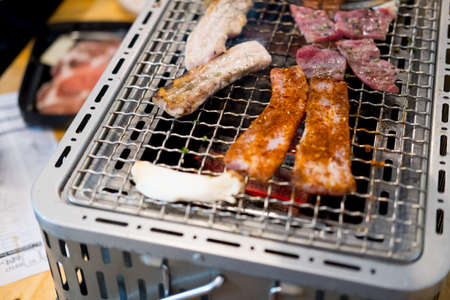 Many of meat slices grilled on stove in the restaurantの写真素材