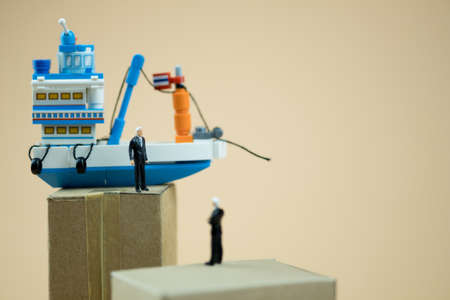 Miniature people: Business people standing on paper box with Thai fishing ship. concept of cargo shipping and import exportの写真素材