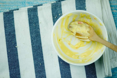 Stains homemade creamy potato salad in bowl after eat on wood blue background