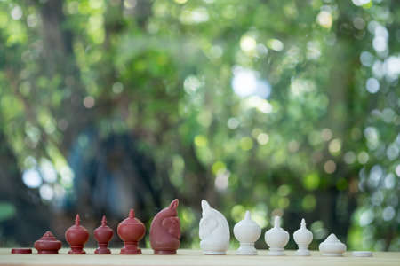 Fighting between white and black knights on wood table, Thai chessの写真素材