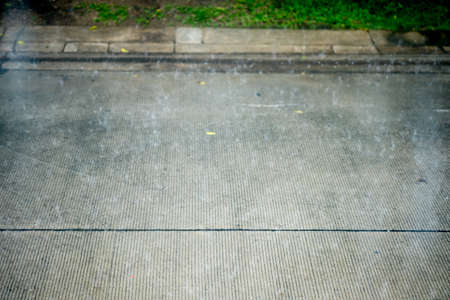 A cement road side after rain, close up.