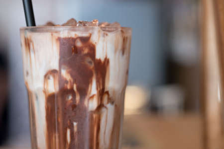 Iced chocolate in clear glass showing the texture chocolate sauce mix milk and refreshing look of the drinkの写真素材