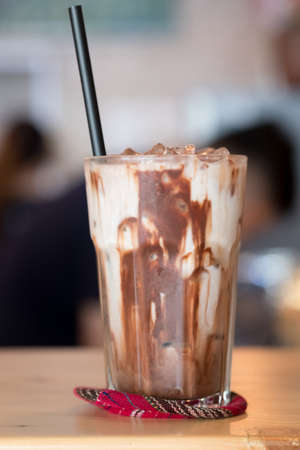 Iced chocolate in clear glass showing the texture chocolate sauce mix milk and refreshing look of...