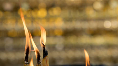 Asian Thai people and foreigner burning candle at joss stick pot or thurible for respect and pray...