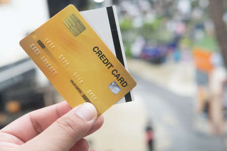 Close up of credit card with paper cinema ticket in hands. Concept of pay by credit cardの写真素材