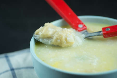 Eating rice gruel mix with raw egg with minced pork. Rice porridge or congee dish in the morning