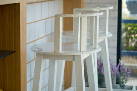 White wooden bar stools in a row in coffee shop