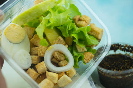 Lunch box with boiled egg and vegetable salad in a plastic clear box. View from above.の写真素材