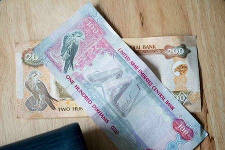 United Arab Emirates Dirham with wallet on wood table