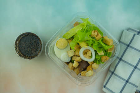 Healthy salad in a plastic clear box served with sesame salad dressing. Top viewの写真素材