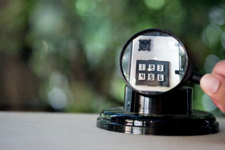 Magnifying glass on the number pad lock on safe box. Concept of security and protection