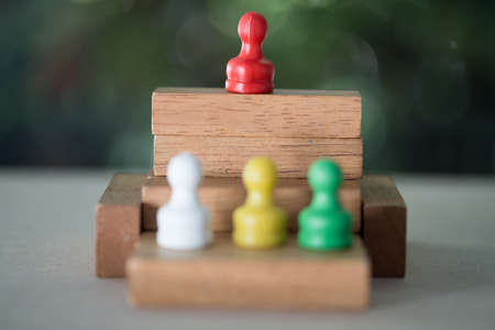 One red pawn on base over any colors pawns. Focus on the red pawn. Concept to symbolize leadership and success.の写真素材
