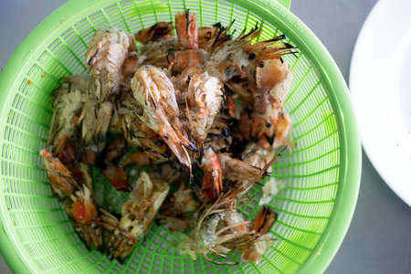 Waste food of grilled shrimp in green basketの写真素材