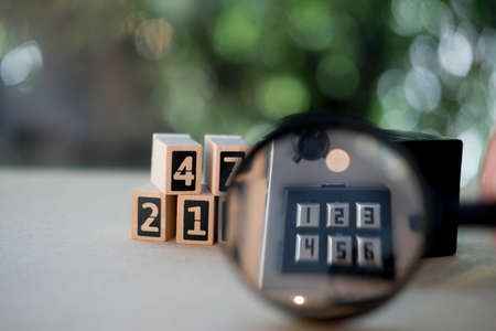Magnifying glass on the number pad lock on safe box. Concept of security and protectionの写真素材