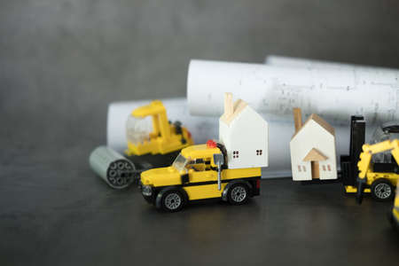 A set of yellow construction car transports wooden houses. Machines for building servicesの写真素材